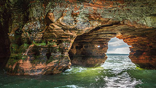 Waves flow through the arched sandstone sea caves on the coast of Lake Superior in Wisconsin.