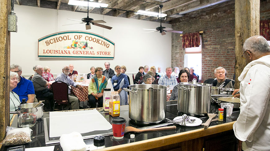 A chef gives a cooking demonstration to an attentive audience at the New Orleans School of Cooking in Louisiana.